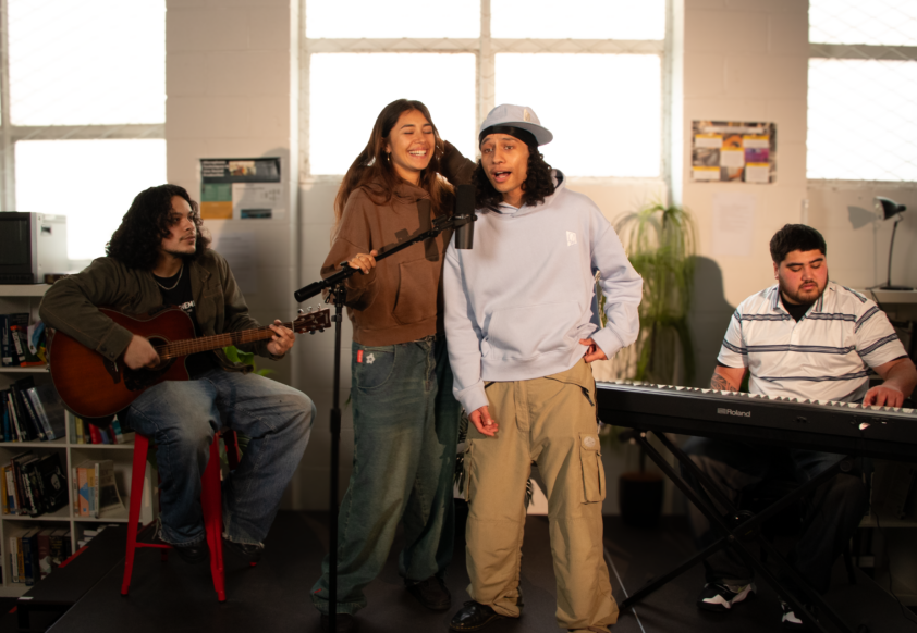 four Maori and Pacific Students on stage preforming